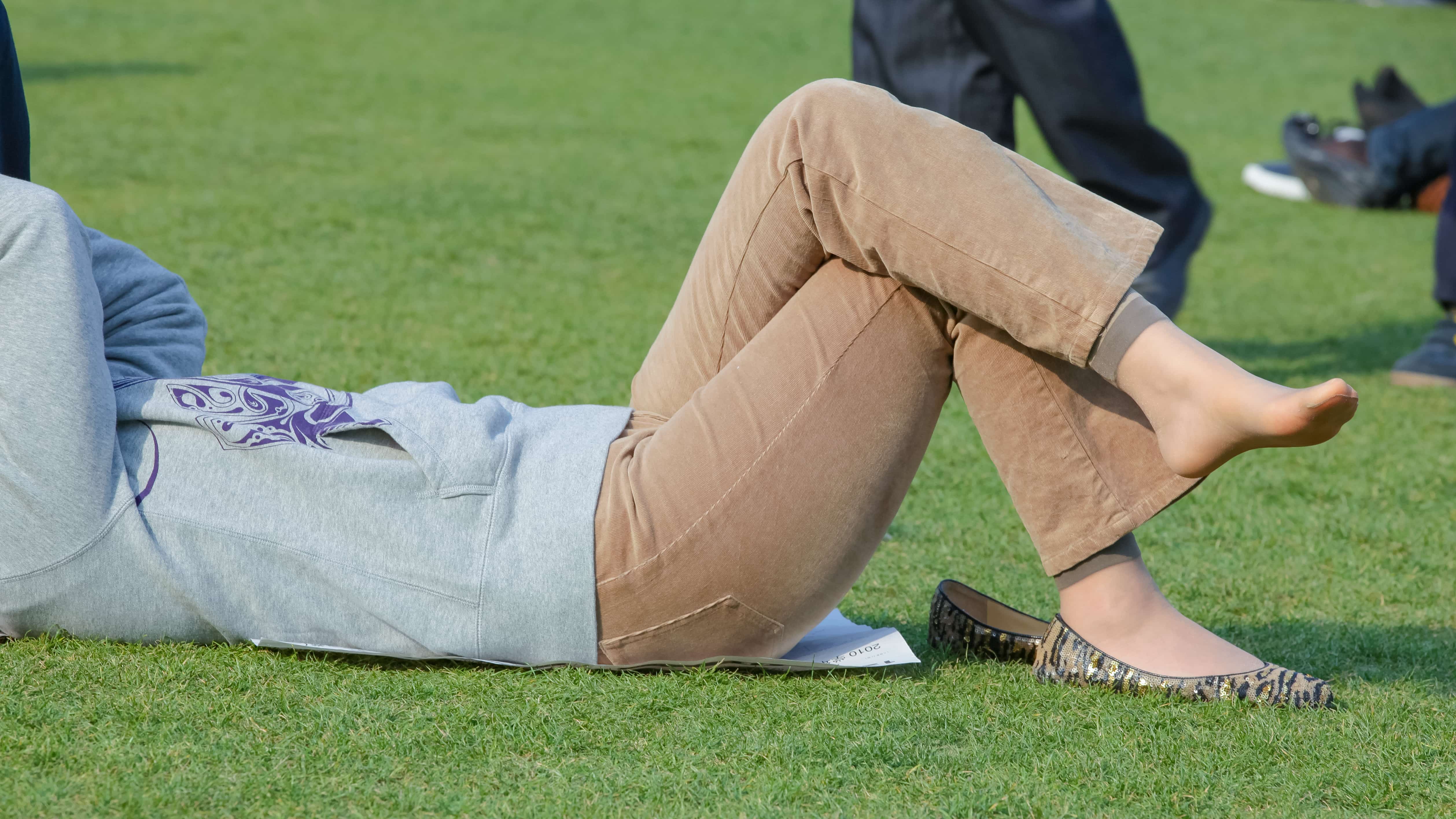 Nude hosiery toes wiggling on grass